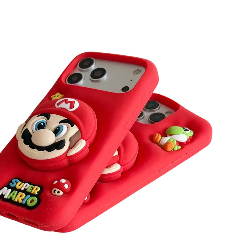 A hand holds a red 3D Super Mario phone case featuring a raised Mario character and 'SUPER MARIO' text, with a second matching red phone case partially visible behind it on a light tabletop.