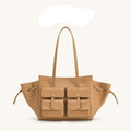 A tan leather tote bag with dual shoulder straps, two front flap pockets with gold-tone hardware, and side drawstring details, shown on a light beige background with the brand name 'JW PEI' above it.